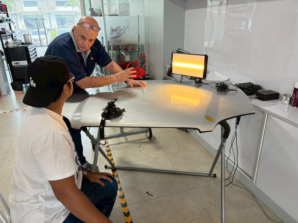 Kevin Duffy teaching PDR beside a training panel at M&H Group, Bangkok
